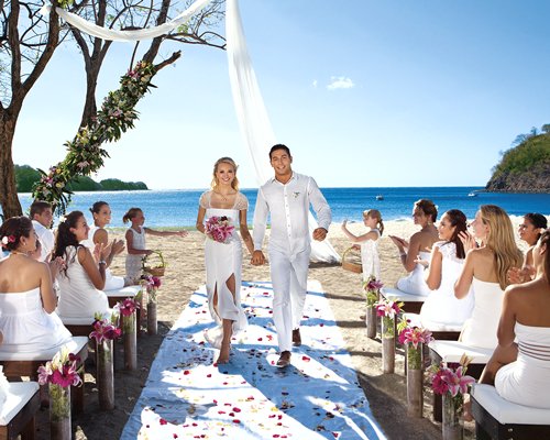 View of people and a couple at an outdoor venue alongside the ocean.