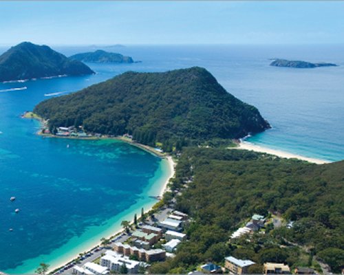 Exterior view of Ramada Resort Shoal Bay at a wooded area alongside the ocean.