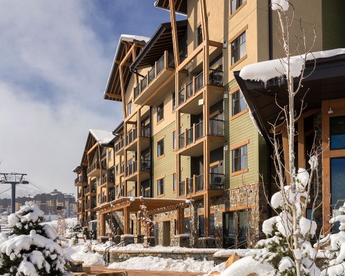 AN EXTERIOR VIEW OF THE WYNDHAM PARK CITY COVERED IN SNOW.