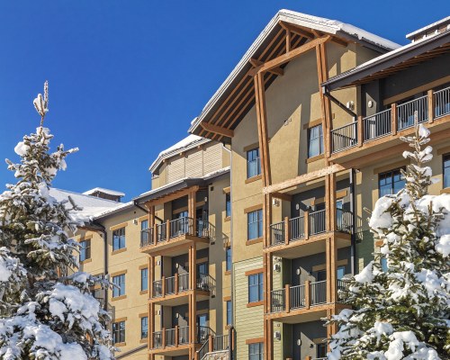 AN EXTERIOR VIEW OF MULTI STORY UNITS COVERED WITH SNOW.