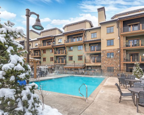 AN OUTDOOR SWIMMING POOL WITH PATIO FURNITURE ALONGSIDE THE RESORT DURING WINTER.
