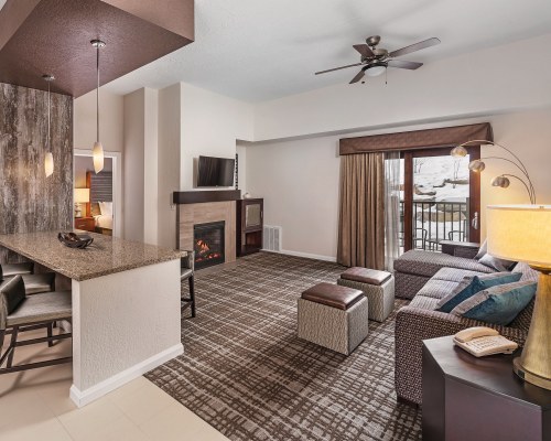 A WELL FURNISHED LIVING ROOM WITH A TELEVISION FIREPLACE AND DINING AREA.