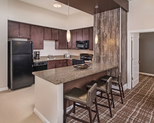 A WELL EQUIPPED KITCHEN WITH BREAKFAST BAR.