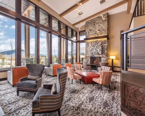 AN INDOOR LOUNGE AREA WITH A FIRE IN THE FIREPLACE.