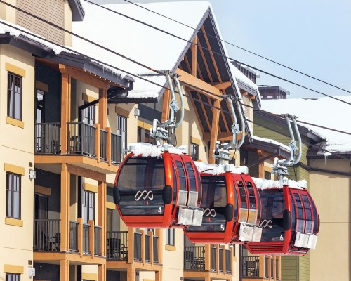 VIEW OF CABLE CARS ALONGSIDE MULTIPLE BALCONIES.
