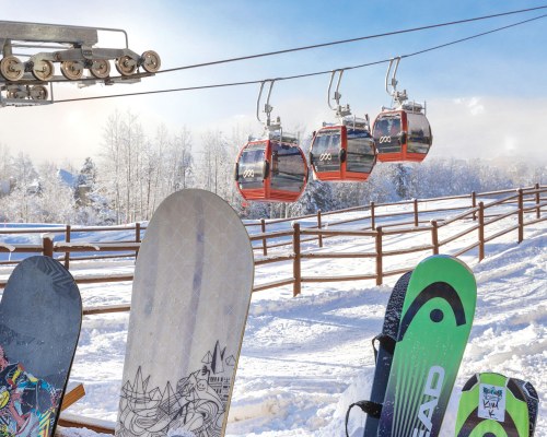 VIEW OF CABLE CARS ALONGSIDE SNOW COVERED AREA.