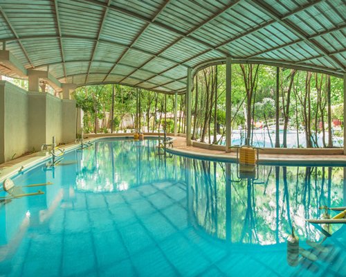 An indoor swimming pool with an outside view.