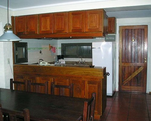 A well equipped kitchen with wooden dining table.