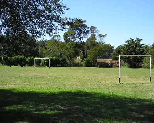 A scenic outdoor football court surrounded by trees.