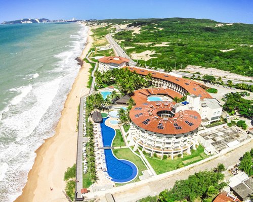 An aerial view of the beach and the hotel properties with the trees.