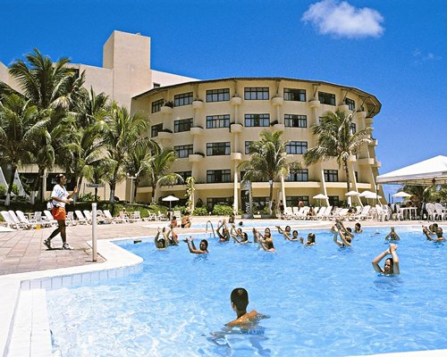 People exercising in an outdoor swimming pool at Hotel Parque Da Costeira.