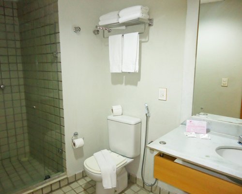 A bathroom with a shower stall and single sink vanity.