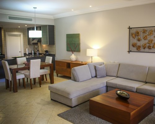 A well furnished living room with a television and an open plan kitchen.