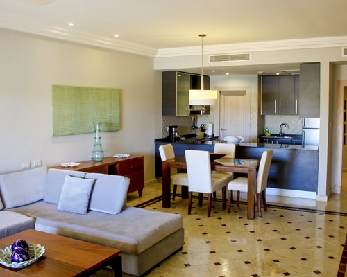 A well furnished bedroom with king bed chaise lounge chair and balcony view.