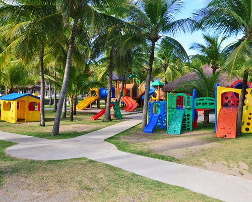 An outdoor playscape surrounded by trees.