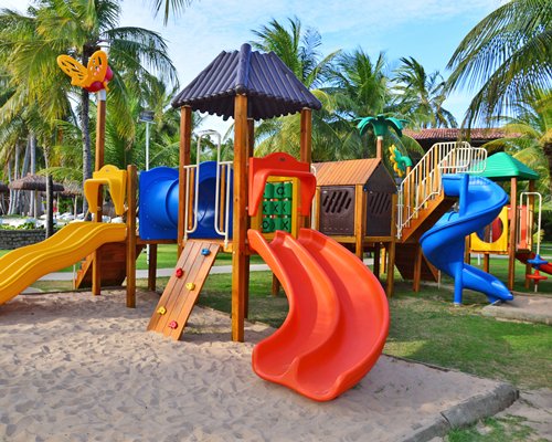 An outdoor kids playscape with trees.