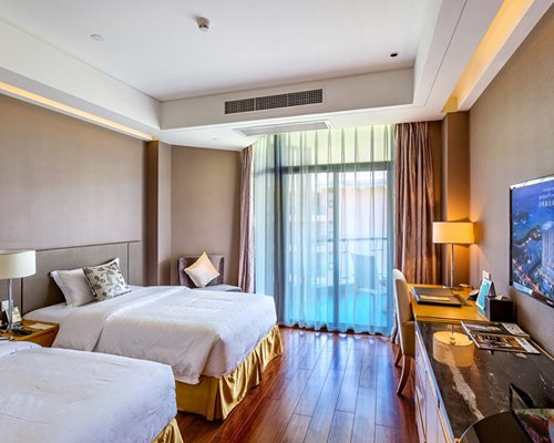 A well furnished bedroom with two beds and a television.