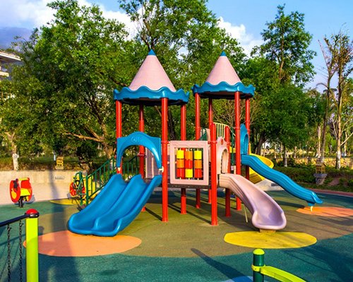 An outdoor playscape alongside trees.