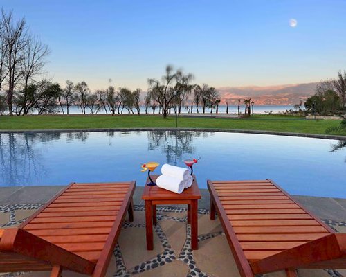 View of chaise lounge chairs alongside the waterfront.