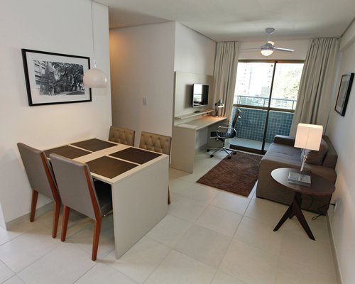 A well furnished living room with a television and dining table.