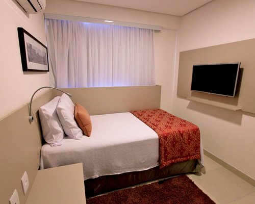 A well furnished bedroom with a television.