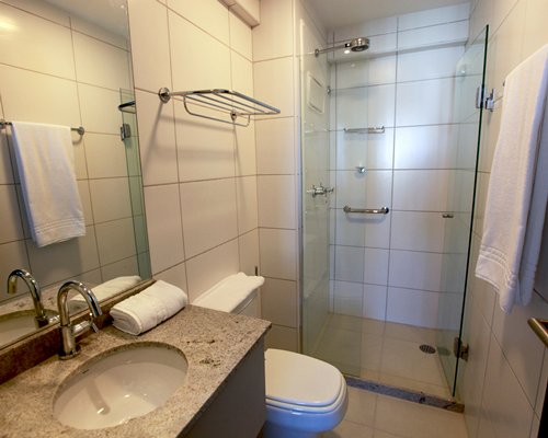 A bathroom with a standing shower stall and single sink.