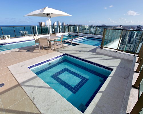 An outdoor swimming pool and hot tub on the terrace.