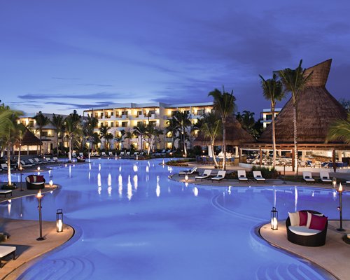 Large outdoor swimming pool alongside the resort at dusk.