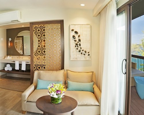 A well furnished living room with a loveseat and a balcony.