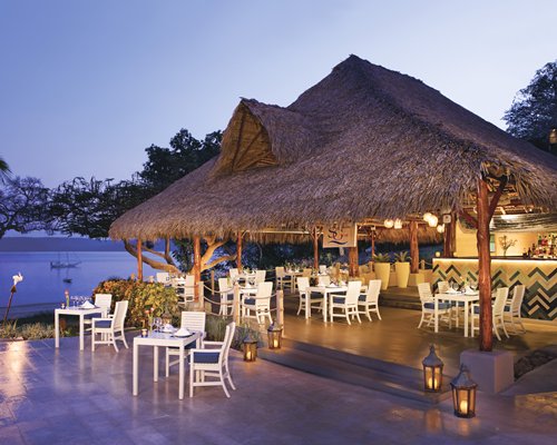 A well furnished outdoor fine dining area at dusk.