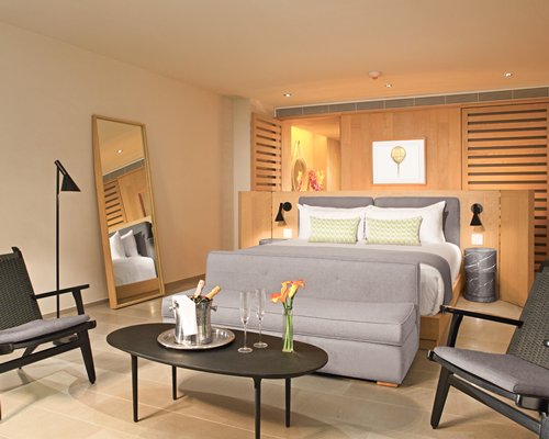 A well furnished bedroom with king bed and living area.