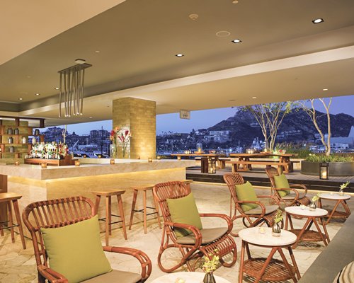 An indoor bar at the resort with an outside view.