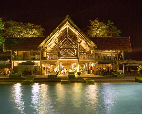 Night view of the hotel with an outdoor pool.