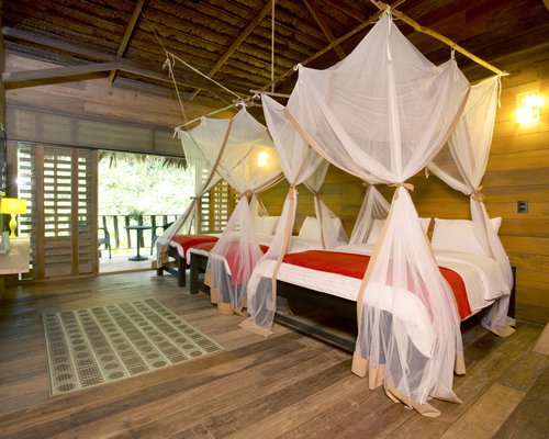 A well furnished bedroom with two beds and balcony.
