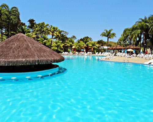 An outdoor swimming pool with a swim up pool bar and chaise lounge chairs.