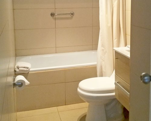 A bathroom with a closed sink vanity and bathtub.