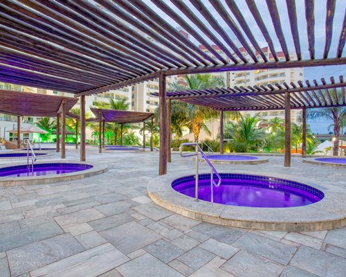 An outdoor pool with a swim up bar alongside resort units.