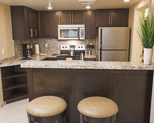 A well equipped kitchen with a microwave oven and a breakfast bar.