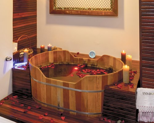 A wooden barrel tub covered in flower petals.