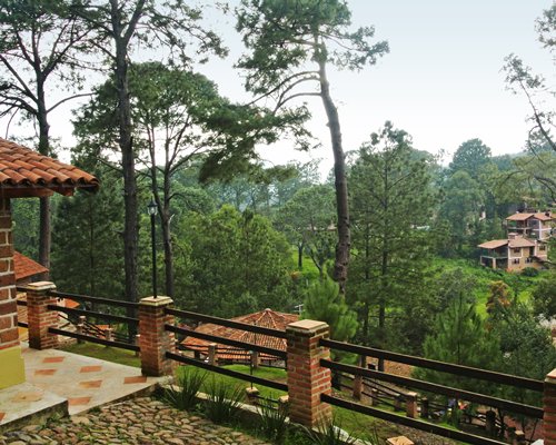 Balcony with view of units at a wooded area.