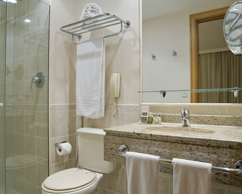 A bathroom with a standing shower stall and single sink.