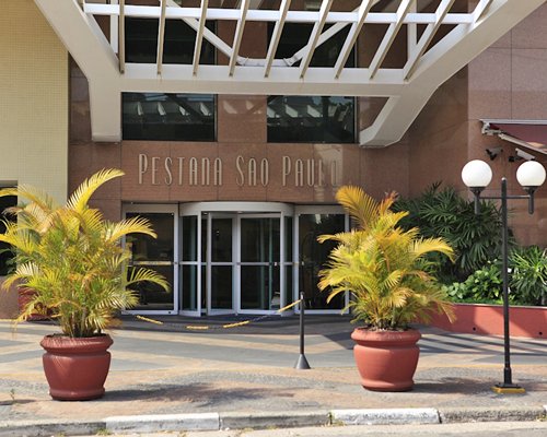 An exterior view of Pestana Sao Paulo resort with potted plants.