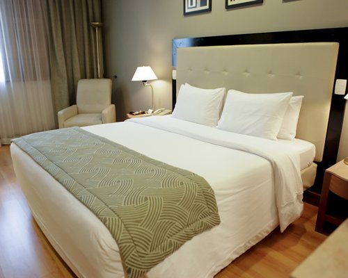 A well furnished bedroom with a queen bed and an outside view.