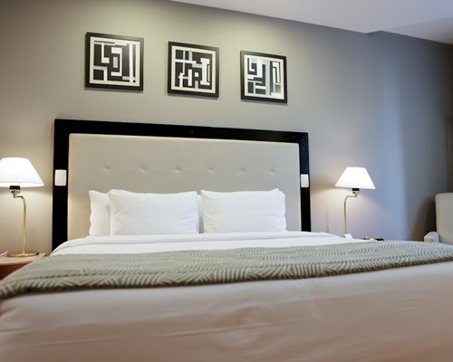 A well furnished bedroom with lamps.