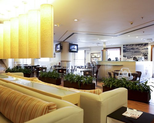 An indoor lounge area with televisions alongside reception counter.
