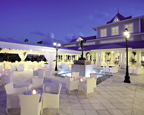 An outdoor fine dining restaurant alongside the resort at dusk.