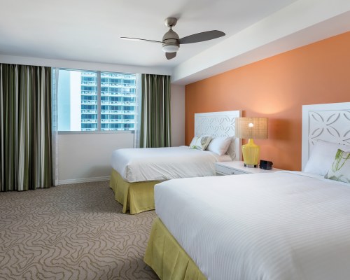A WELL FURNISHED BEDROOM WITH TWO TWIN BEDS AND OUTSIDE VIEW.