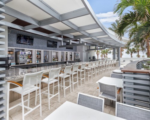 AN OUTDOOR FINE DINING AREA AT THE RESORT WITH A BAR.