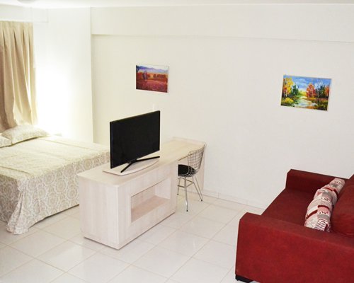 A well furnished living room with a television and bedroom.