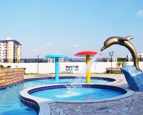 An outdoor swimming pool with raining mushroom umbrella and the water features.